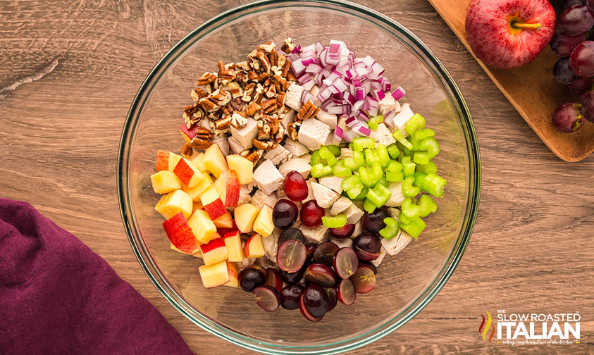 ingredients for chicken salad with grapes and apples in a large mixing bowl