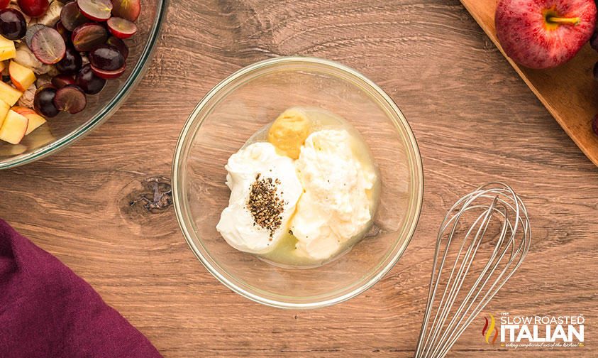 dressing for chicken salad with grapes and apples in a small glass bowl