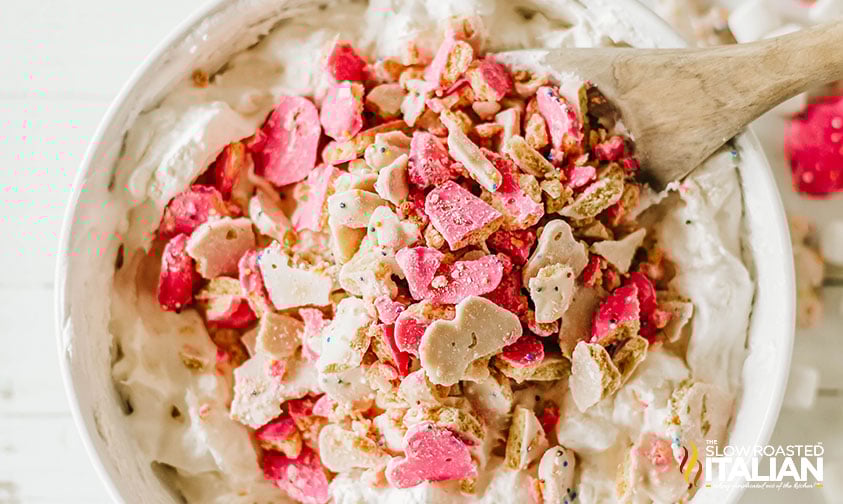 adding chopped circus cookie pieces to fluff salad