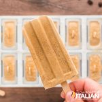 closeup of of a hand holding coffee popsicles