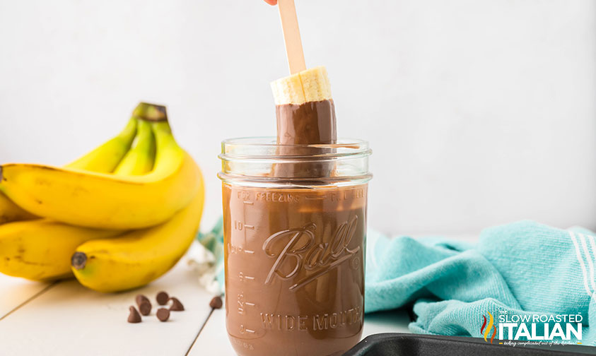 dipping a frozen banana in melted chocoltae