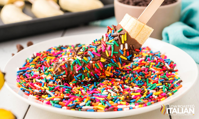 adding sprinkles to chocolate covered bananas