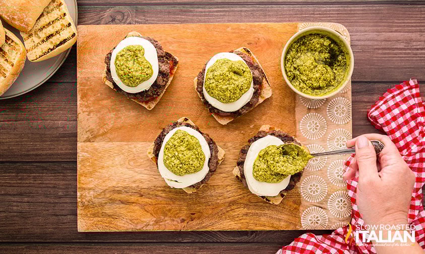 adding pesto to caprese burger