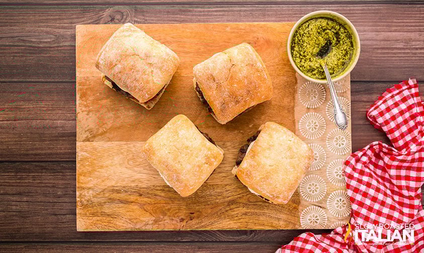 4 pesto burgers on a wooden board