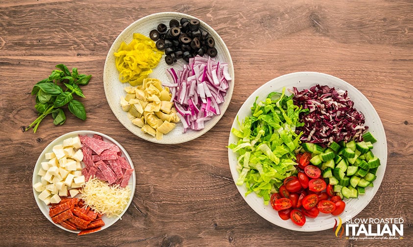 ingredients for italian chopped salad measured on white plates