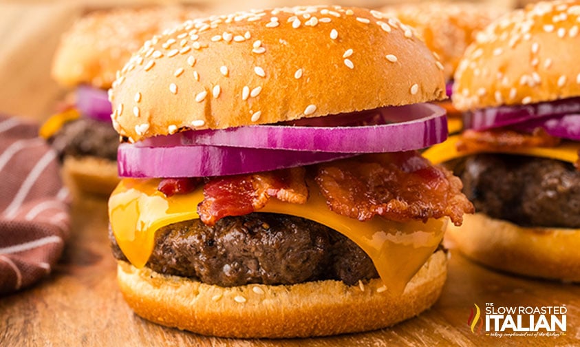 closeup of bbq bacon burger on a wooden board