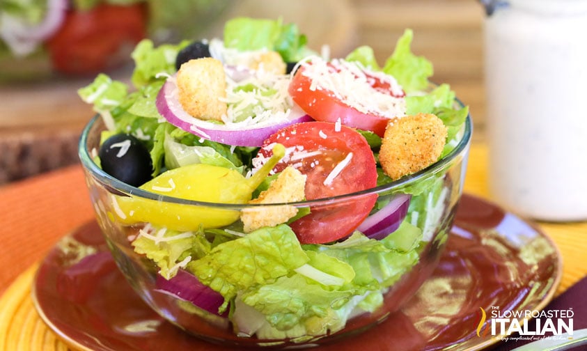 olive garden salad with lettuce, olives, pepperoncini, and italian dressing