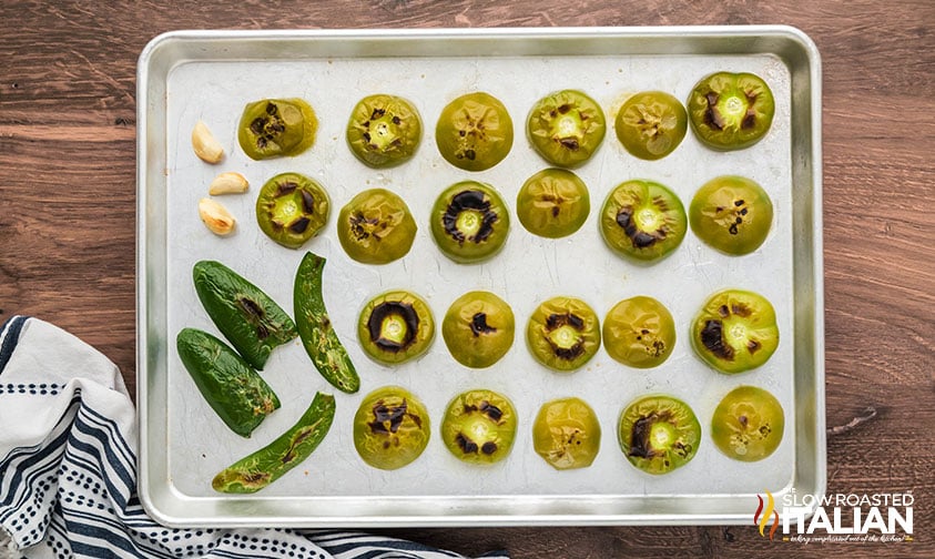tomatillos, jalapeno peppers, and garlic cloves on a sheet pan broiled for making roasted salsa verde