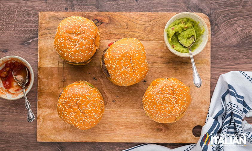 guacamole burgers on a wooden board