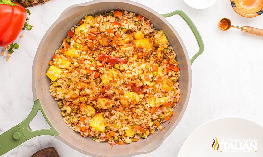 frying thai pineapple fried rice in a large skillet