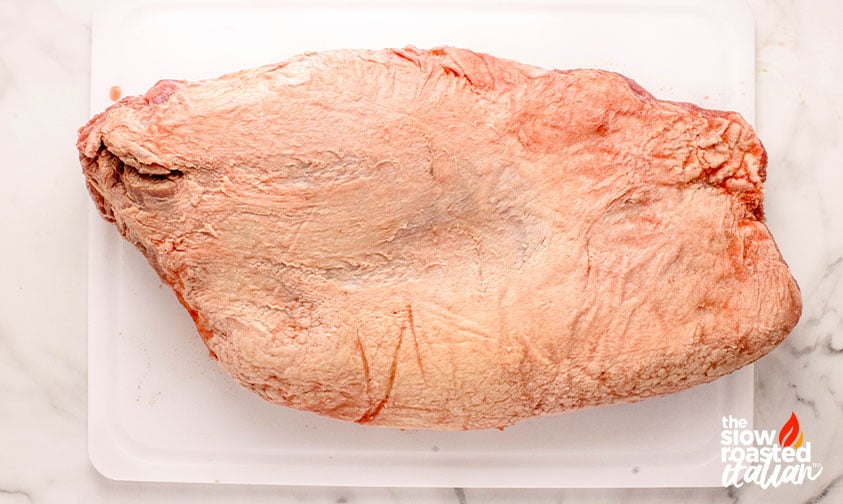 untrimmed brisket on a cutting board