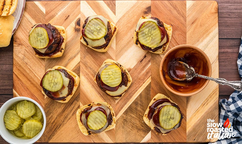 loading bbq sliders with pickles and extra sauce
