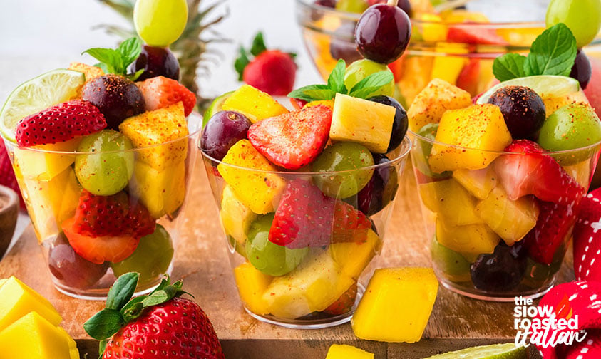 cups of mexican fruit salad on a wooden tray