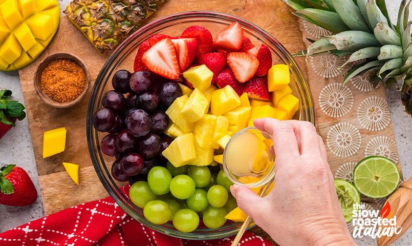 adding lime juice to mexican fruit salad