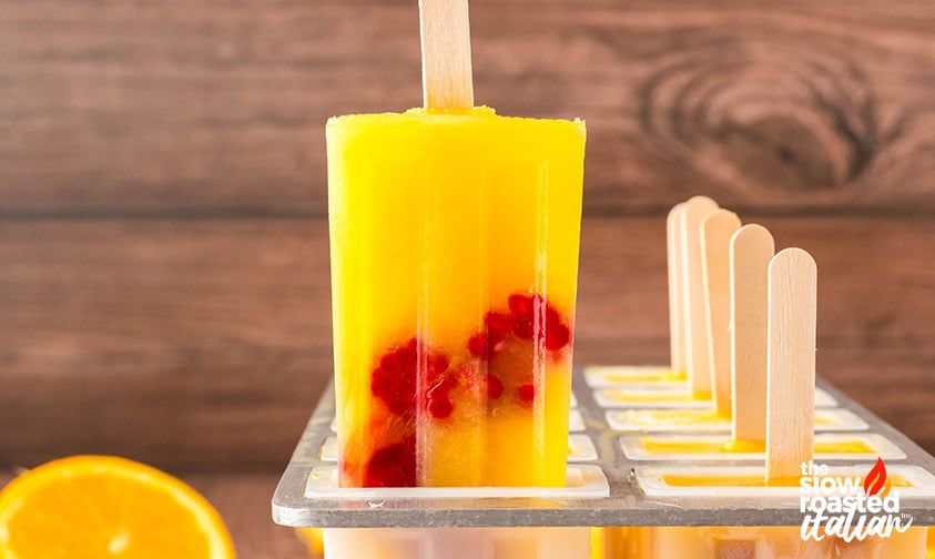 pulling orange juice popsicles from the ice pop mold