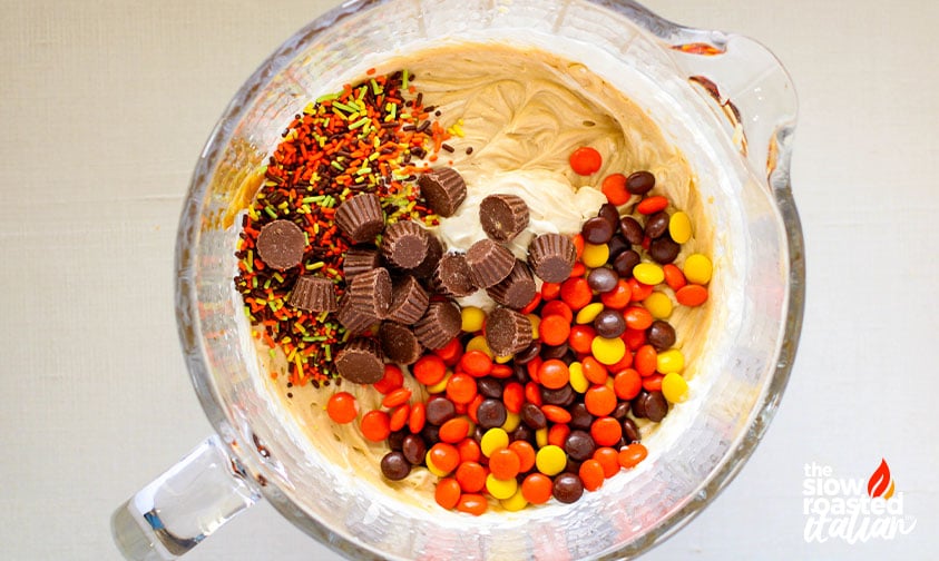adding sprinkles, reese's pieces, and mini peanut butter cups to reese's peanut butter ice cream base