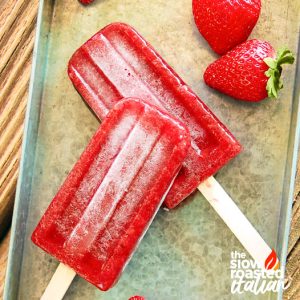 closeup of strawberry ice pops on a tray with fresh strawberries