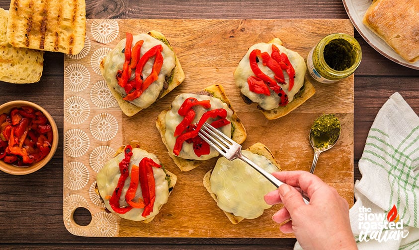 adding topping to Mediterranean Burger
