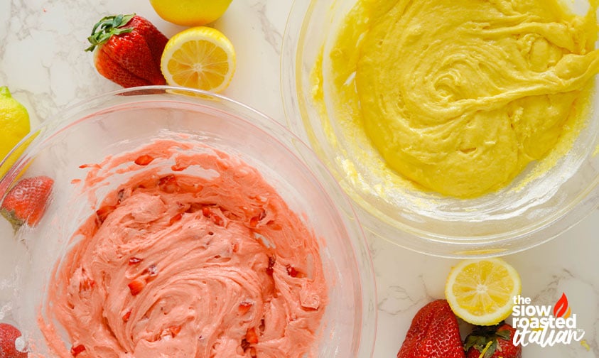 Pink strawberry batter and yellow lemon batter in separate bowls, ready to be swirled together for strawberry brownies