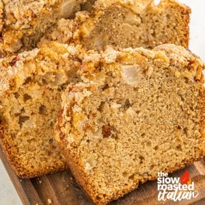 Close-up of sliced apple bread with a cinnamon streusel topping and pecans