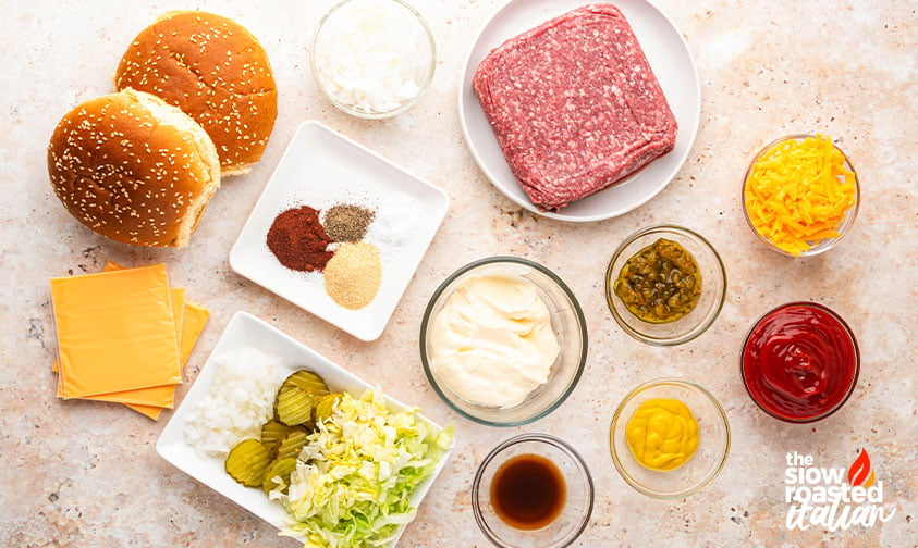 Ingredients for Big Mac sloppy joes including ground beef, sesame buns, cheese slices, pickles, shredded lettuce, mayo, ketchup, and mustard