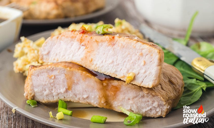 Close-up of sliced marinated pork chops with golden caramelized edges, topped with chopped green onions