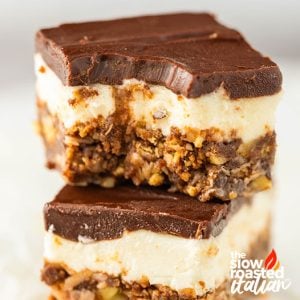 Stacked Nanaimo bars with chocolate ganache top layer, creamy filling, and a chunky nut and oat crust