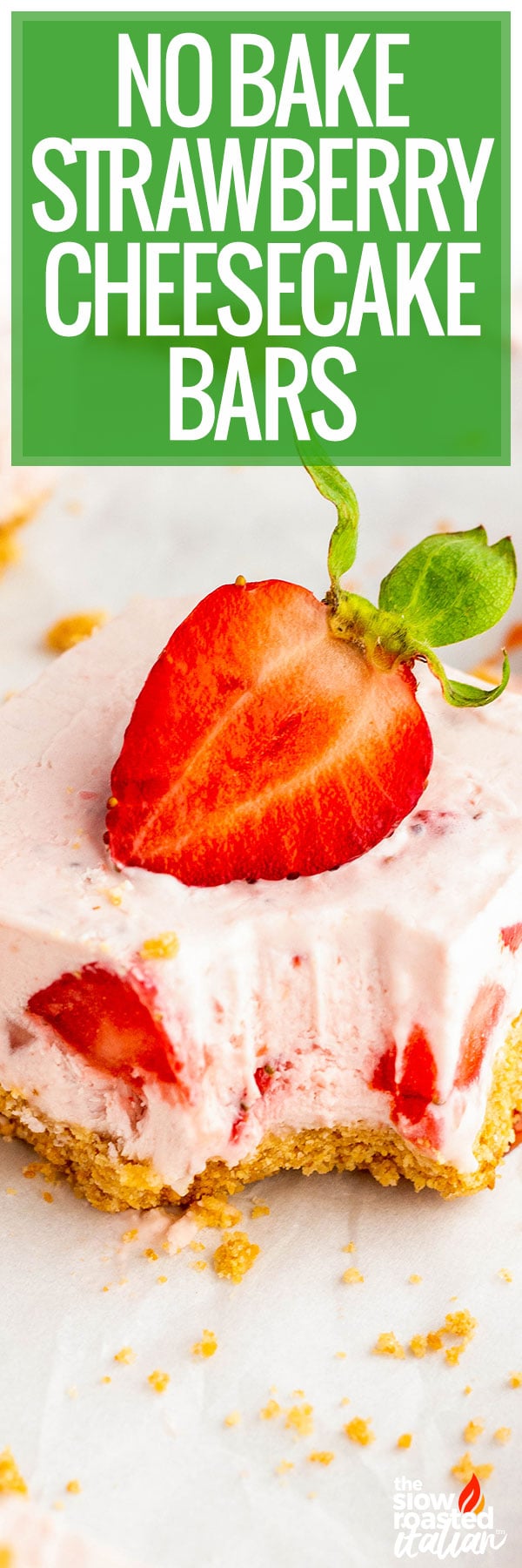 No bake strawberry cheesecake bar with a bite taken out, showing the graham cracker crust and creamy strawberry filling, topped with a fresh strawberry