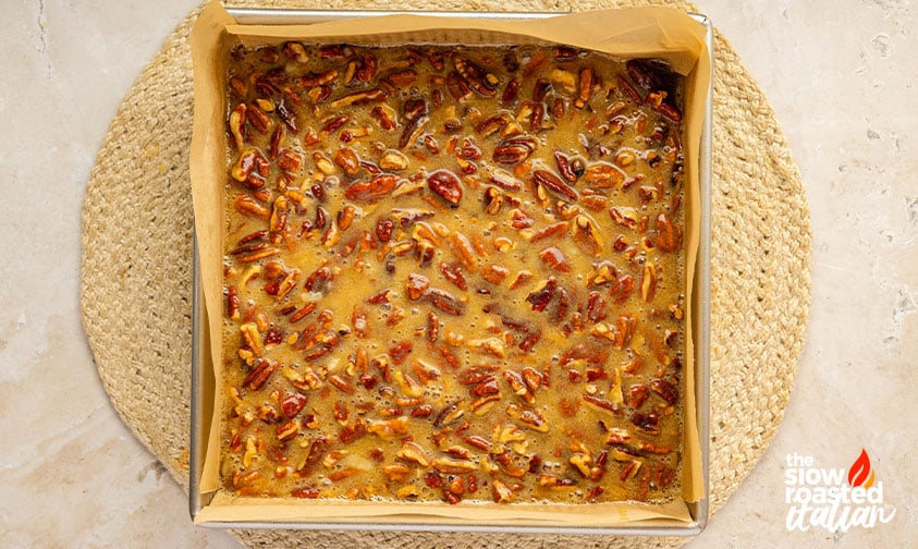 Process: pecan pie topping spooned over the brownies from the edges in