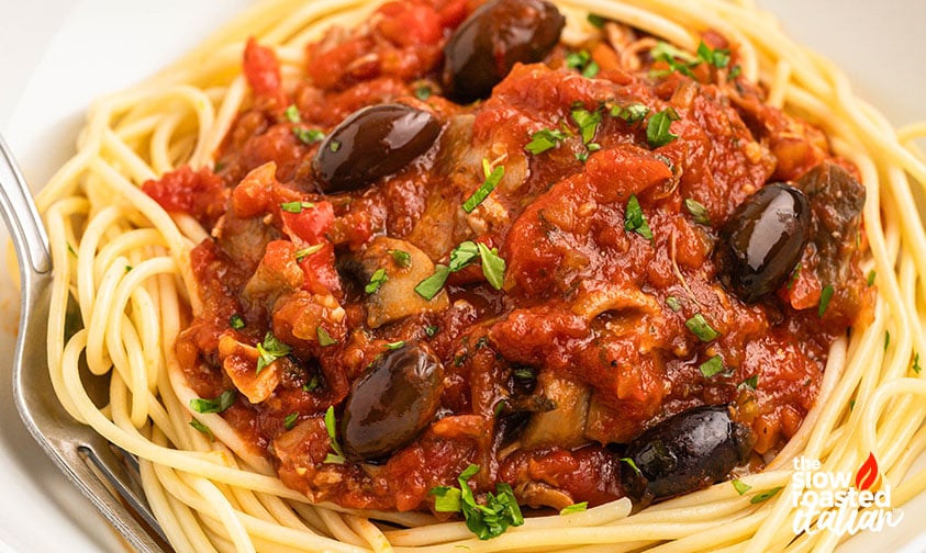 Serving: chicken cacciatore spooned over pasta with chopped Italian parsley