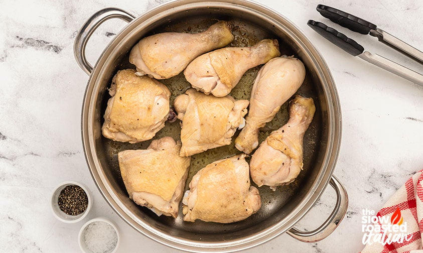 Process, sear: bone-in chicken thighs and drumsticks searing skin side down in a Dutch oven